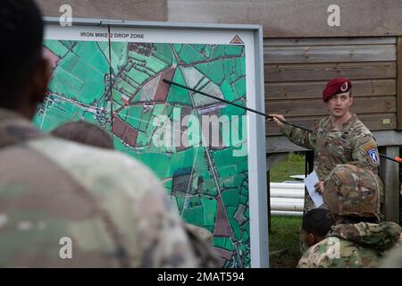 NEGLI STATI UNITI Comandante dell'esercito con la Brigata aerea 173rd orienta i paracadutisti nella loro zona di caduta in preparazione di un'operazione aerea in onore del D-Day durante l'addestramento aereo sostenuto (SAT) a Sainte-Mere-Eglise, Francia, 4 giugno 2022. Il 6,1944 giugno, più di 150.000 truppe delle forze alleate invasero la Normandia, la Francia, dal mare e dall'aria. Più di 23.000 paracadutisti alleati hanno partecipato all'invasione. (STATI UNITI Foto dell'esercito del personale Sgt. Alexander Skripnichuk) Foto Stock