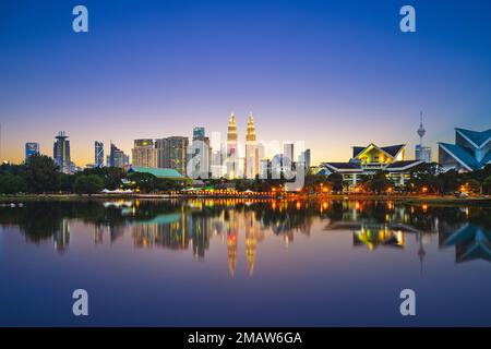 Skyline di Kuala Lumpur dal lago al tramonto Foto Stock