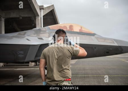 NEGLI STATI UNITI Il capo dell'equipaggio dell'aeronautica assegnato al 154th Aircraft Maintenance Squadron saluta un pilota di F-22 Raptor mentre si sposta in taxi sulla linea di volo alla base aerea di Kadena, Giappone, 6 giugno 2022. Aerei, equipaggi aerei e personale di terra della 154th Wing conducono missioni fuori da Kadena a sostegno del continuo impegno a mantenere un libero e aperto Indo-Pacific. Foto Stock