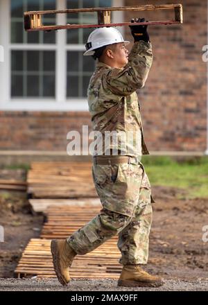 Tecnico. Kai Chantavong, un artigiano della produzione di energia elettrica con l'ingegnere civile 124th Squadron, Boise, Idaho, porta un pallet presso il sito del progetto di formazione per la preparazione innovativa della Nazione Cherokee a Tahlequah, Oklahoma, 6 giugno 2022. I pallet sono stati utilizzati per costruire percorsi improvvisati attraverso il sito di costruzione fangoso a causa delle recenti tempeste di pioggia. Foto Stock