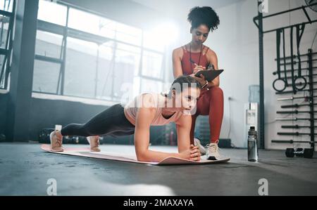 Personal trainer, fitness e appunti con una donna nera che istruisce un cliente in palestra durante il suo allenamento. Salute, esercizio fisico o formazione e una donna Foto Stock