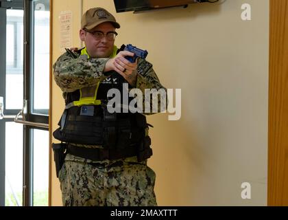 WHITE BEACH, Giappone (7 giugno 2022) Master-at-Arms 2nd Class Cody Chronister, assegnato al comandante, reparto di sicurezza per le attività della flotta Okinawa, tiene una pistola di addestramento della gomma su un sospetto armato in un esercizio di addestramento sulla CFAO White Beach Naval Facility, Okinawa, Giappone 7 giugno 2022. La CFAO mantiene e gestisce strutture a sostegno degli Stati Uniti Le attività navali e aeronautiche della Marina nella regione di Indo-Pacifico. Foto Stock