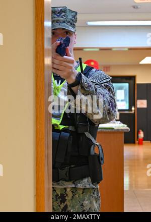 WHITE BEACH, Giappone (7 giugno 2022) Master-at-Arms 3rd Classe Tyler Ferarizimmerman, assegnato al Comandante, attività della flotta reparto di sicurezza di Okinawa, tiene una pistola di addestramento della gomma su un sospetto armato in un esercizio di addestramento sulla CFAO White Beach Naval Facility, Okinawa, Giappone 7 giugno 2022. La CFAO mantiene e gestisce strutture a sostegno degli Stati Uniti Le attività navali e aeronautiche della Marina nella regione di Indo-Pacifico. Foto Stock