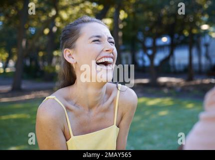 Felicità, giovane donna e casual nel parco, estate e gioioso con abiti alla moda, ridendo e agghiacciante. Felice femmina, signora e sorridere all'aperto, divertente Foto Stock