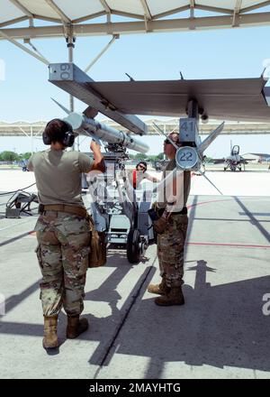 Staff Sgt. Dyshay Smagacz, staff Sgt. Hector Rodgriguez Jr., e Tech Sgt. Joseph Ramos, 149th tecnici di sistemi di armamento aerei di Fighter Wing, lavorano per spostare un missile di addestramento da un F-16 all'altro presso la base comune di San Antonio-Lackland, Texas, 7 giugno 2022. I tecnici dei sistemi di armamento degli aeromobili sono responsabili della manutenzione dei sistemi di armamento dell'aeromobile e della configurazione dei carichi per ogni volo. (Foto della Guardia Nazionale aerea del personale Sgt. Ryan Mancuso) Foto Stock