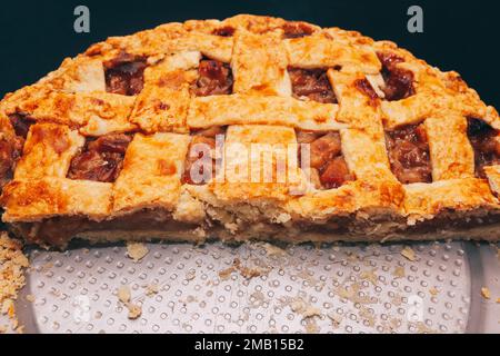 Torta di mele rustica, nella teglia rotonda, con crosta di lattice, tagliata, vista dall'alto Foto Stock