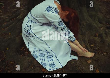 Primo piano stanca donna a piedi nudi in ricamo abito concetto foto Foto Stock