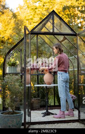 Fiorista donna fa un bel bouquet in serra sul retro cortile Foto Stock