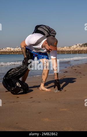 220610-N-QI593-1075 ROTA, Spagna (10 giugno 2022) Ospedale Corpsman 2nd Classe James Shelvay, da Buffalo, New York, raccoglie i rifiuti durante una pulizia della spiaggia a Admiral’s Beach, 10 giugno 2022. Bainbridge è in fase di distribuzione pianificata negli Stati Uniti Naval Forces Europe area of Operations, impiegato dagli Stati Uniti Sesta flotta per difendere gli interessi degli Stati Uniti, degli alleati e dei partner. Foto Stock