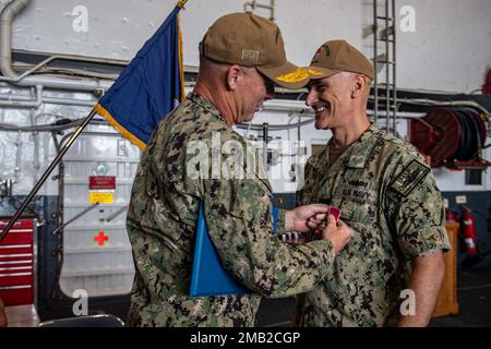 SASEBO, Giappone (10 giugno 2022) il capitano Greg Baker, Commodore, Squadrone anfibio 11, a destra, riceve la Legione del merito durante la sua cerimonia di cambio di comando nella baia di hangar della nave portuale anfibio da trasporto USS New Orleans (LPD 18). Lo Squadrone anfibio 11 opera nell'area di responsabilità della flotta degli Stati Uniti 7th per migliorare l'interoperabilità con alleati e partner e funge da pronta forza di risposta per difendere la pace e la stabilità nella regione dell'Indo-Pacifico. Foto Stock