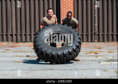 Gli airmen assegnati al 4th Logistics Readiness Squadron ribaltano un pneumatico durante un corso di ostacolo in un rodeo di trasporto a terra alla base aerea di Seymour Johnson, Carolina del Nord, 10 giugno 2022. L'evento ha sottolineato le sfide di team building legate al lavoro quotidiano in 4th campi di carriera LRS. Foto Stock