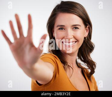 Smetti e sorridi. Studio shot di una giovane donna che mostra il palmo della mano su uno sfondo bianco. Foto Stock