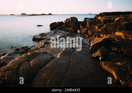 Rocce sulla spiaggia di Port Blanc nella luce del mattino, Bretagna, Francia Foto Stock