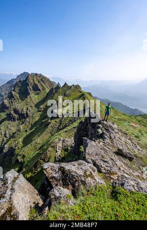 Escursionisti sulle rocce, cime verdi di montagna appuntite sul crinale di Tindfjoell, rocce di tufo troppo cresciute, natura selvaggia, Highlands islandesi, Porsmoerk Foto Stock