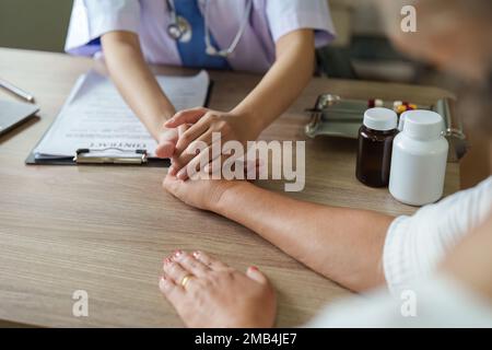 Dottore che dà speranza. Primo piano del medico che tiene la mano della paziente anziana della signora. Infermiere sanitario domestico, terapia fisica con donna adulta anziana Foto Stock