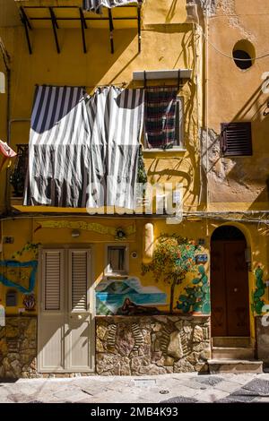 Facciata splendidamente colorata di un edificio residenziale di Palermo con balcone. Foto Stock