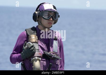 220613-N-XN177-1039 MARE DELLE FILIPPINE (13 giugno 2022) – Aviazione Boatswain’s Mate (Fuels) Airman Andrew Belanga, di San Antonio, si prepara a rifornire un aereo sul ponte di volo della portaerei d’assalto anfibio USS Tripoli (LHA 7), 13 giugno 2022. Tripoli opera nell'area delle operazioni della flotta 7th degli Stati Uniti per migliorare l'interoperabilità con alleati e partner e fungere da pronta forza di risposta per difendere la pace e mantenere la stabilità nella regione dell'Indo-Pacifico. Foto Stock