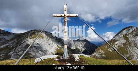 Una vista panoramica di una croce situata sulla cima di una montagna vista durante il giorno Foto Stock