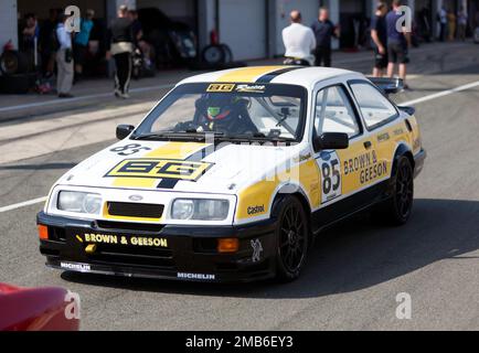 Daniel e Sean Brown's 1990, Ford Sierra Cosworth RS500 nel Pit Lane alla fine del Tony Dron Memorial Trophy per MRL Historic Touring Cars. Foto Stock