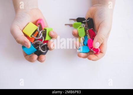 Il bambino lavora con materiale Montessori con serrature colorate. Raccoglie i tasti. Sviluppa le abilità motorie fini. Foto Stock