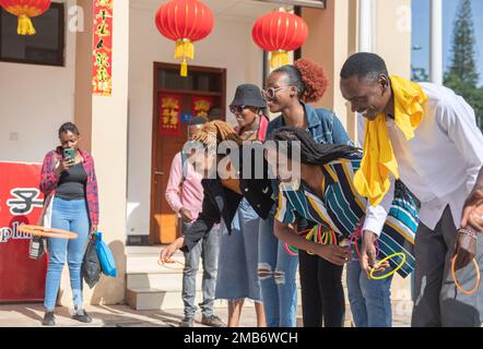 Nairobi, Kenya. 19th Jan, 2023. La gente partecipa a un gioco di ring toss durante un evento di celebrazione del Capodanno cinese a Nairobi, Kenya, 19 gennaio 2023. Per celebrare il prossimo Capodanno cinese, il Confucio Institute presso l'Università di Nairobi ha tenuto un evento di celebrazione il Giovedi. Una serie di attività funge da ponte per migliorare la comprensione reciproca tra il popolo cinese e quello keniota, consentendo alle persone di sperimentare l'essenza della cultura cinese tradizionale. Credit: Li Yahui/Xinhua/Alamy Live News Foto Stock