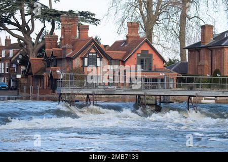 Marlow, Buckinghamshire, Regno Unito. 20th gennaio 2023. Acqua fluente veloce a Marlow Weir. Il Tamigi a Marlow ha scoppiato le sue rive dopo una forte pioggia all'inizio di gennaio. I livelli dell'acqua stanno cominciando a scendere ma ci è ghiaccio sul percorso del Tamigi dove l'acqua di inondazione si è congelata sopra. I livelli dell'acqua sono ora alla stessa altezza del sentiero in alcuni luoghi. Un allerta alluvione rimane in atto per il Tamigi da Hurley a Cookham compreso Marlow. Credit: Maureen McLean/Alamy Live News Foto Stock