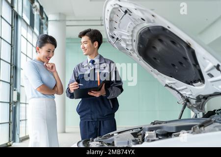 Riparazione di meccanici del personale con il cliente Foto Stock