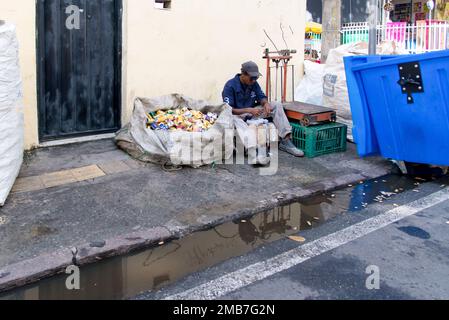 Salvador, Bahia, Brasile - 09 febbraio 2018: Può picker riposo seduto dopo il lavoro nella notte di Carnevale nella città di Salvador, Bahia. Foto Stock