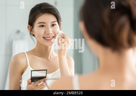 La giovane donna trucco in bagno Foto Stock