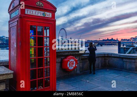 Un turista fotografa il bellissimo tramonto su Londra. Foto Stock