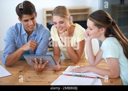 Mostrare loro la sua presentazione. tre colleghi che lavorano in ufficio. Foto Stock