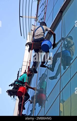 Workers Glass cline un alto edificio in un'area di cantiere a Dhaka Foto Stock