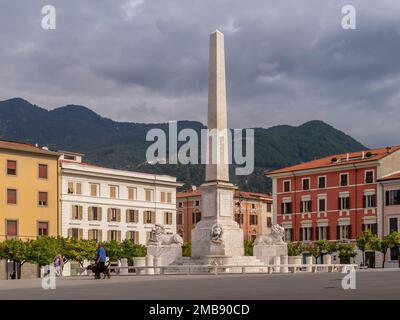 L'obelisco in Piazza Aranci, massa, Italia, sotto un cielo drammatico Foto Stock