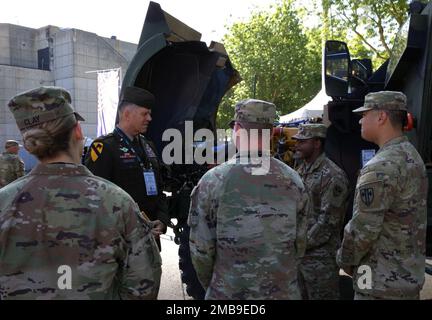 Talik Jackson, un meccanico di veicoli a ruote assegnato alla Brigata militare della polizia 18th, slip Gen. Peter Andrysiak, comandante degli Stati Uniti Esercito Europa e Africa, sulle capacità e i requisiti di manutenzione del veicolo all-Terrain protetto da imboscata resistente alle mine, o MAT-V, all'Eurosatory 2022, giugno 13, a Parigi, Francia. Gli esperti in materia sono essenziali per comunicare in modo efficace le capacità delle apparecchiature degli Stati Uniti e i loro vantaggi alle nazioni partner. Foto Stock