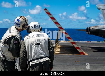 220614-N-DW158-3009 MARE DELLE FILIPPINE (14 giugno 2022) posteriore ADM. Michael Donnelly, a sinistra, comandante, Task Force 70, mostra Brig. Il Gen. Akhai Gandhi, Capo di Stato maggiore, South Carolina Air National Guard, un deflettore jet blast sul ponte di volo degli Stati Uniti L’unica portaerei della Marina schierata a termine, la USS Ronald Reagan (CVN 76) durante l’esercizio Valiant Shield 22. Esercizi come Valiant Shield consentono alla Joint Task Force del comando Indo-Pacific di integrare le forze di tutti i rami del servizio per condurre effetti multi-dominio a lungo raggio, precisi, letali e schiaccianti che dimostrino Foto Stock