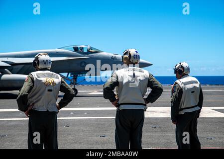 220614-N-DW158-2019 MARE DELLE FILIPPINE (14 giugno 2022) posteriore ADM. Robert Clark, sinistra, Vice Commander, U.S. 7th Fleet, posteriore ADM. Michael Donnelly, centro, Commander, Task Force 70, e Brig. Il generale Akshai Gandhi, capo di stato maggiore, South Carolina Air National Guard, osserva un Super Hornet F/A-18E attaccato ai Dambusters of Strike Fighter Squadron (VFA 195), atterra sul ponte di volo degli Stati Uniti L’unica portaerei della Marina schierata a termine, la USS Ronald Reagan (CVN 76) dopo il ritorno dell’aeromobile da una prova congiunta di sciopero marittimo per dimostrare le capacità di incendio ed effetto dei componenti del servizio in t Foto Stock