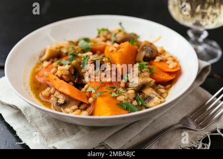 Zucca invernale con funghi, carote orzo cotto al vino bianco. Foto Stock