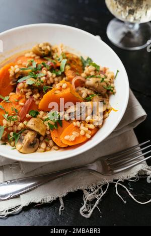 Zucca invernale con funghi, carote orzo cotto al vino bianco. Foto Stock