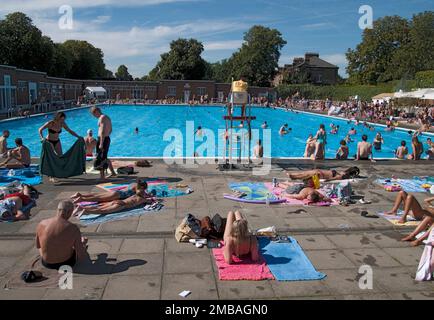 Brockwell Lido, Dulwich Road, Brockwell Park, Lambeth, Greater London Authority, 2012. La piscina al Lido di Brockwell nel Parco di Brockwell, vista dall'estremità nord con i bagnanti in primo piano e un bagnino che guarda i nuotatori in piscina. Il Lido di Brockwell ha aperto nel luglio 1937. È stato progettato da Harry Rowbotham e T L Smithson in uno stile modernista per il London County Council (LCC). Il lido è una delle quattro piscine scoperte costruite, finanziate o gestite da LCC dal 1906 al 1939. È elencato grado II. Foto Stock