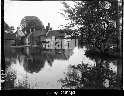 Donnington Brewery, Donnington, Cotswold, Gloucestershire, 1928. Una vista della fabbrica di birra e del mulino di Donnington da nord-ovest attraverso il laghetto del mulino. Foto Stock