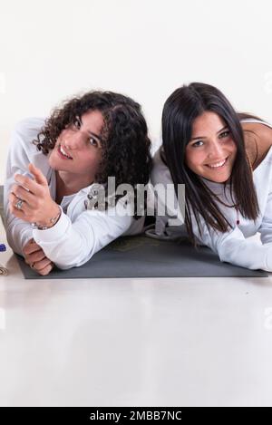 Ritratto di un gruppo di amici yoga che guardano la fotocamera su sfondo bianco. Foto da studio. Foto Stock