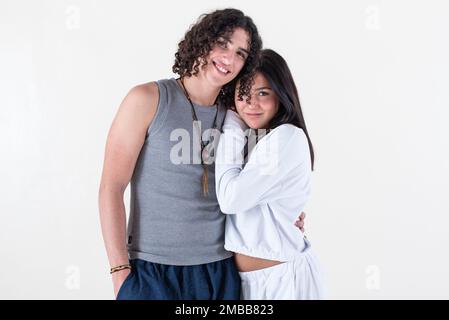 Ritratto di una giovane coppia vestita di abiti yoga guardando la fotocamera sfondo bianco. Foto da studio. Foto Stock