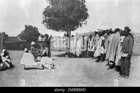 «Nos recrues d'asie, d'Afrique et d'oceanie; en Afrique occiidentale : un palabre aux recrues dans un village de l'Issa-ber (boulle du Niger)», 1916. Da "Collection de la Guerre IV. L'Illustrazione Tome CXLVII. La Guerre Janvier, Fevrier, Mars, Avril, mai, Juin 1916". Foto Stock