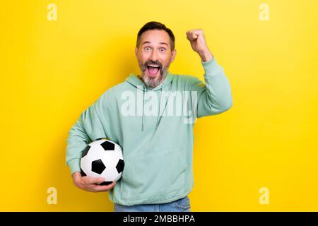 Ritratto dell'uomo allegro gioire vittoria vittoria vittoria squadra di calcio preferita isolato su sfondo giallo Foto Stock