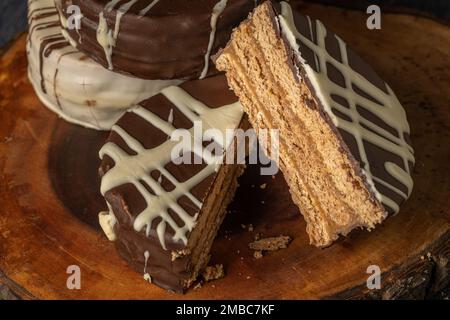 Alfajor tagliato a metà, caramelle tipiche argentine, su una tavola di legno. Foto Stock