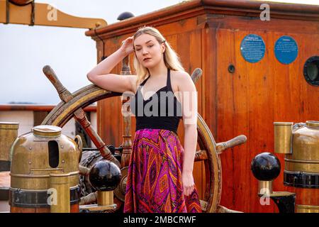 Hayleigh Young, una bella e alla moda donna posa per una fotografia a bordo della nave RRS Discovery in una giornata invernale ghiacciata a Dundee, in Scozia Foto Stock