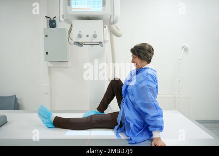 Paziente ottimista sottoposto a procedura diagnostica radiologica nella sala radiologica Foto Stock