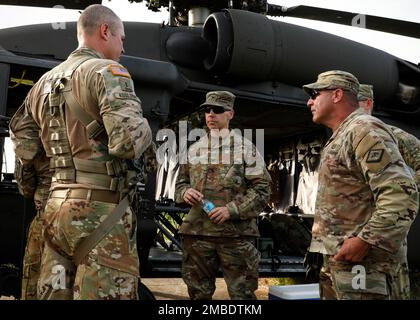 Michael Henderson, Capo dello Stato maggiore della Guardia Nazionale dell'Arkansas, e il comando di Stato Sgt. Maj. Paul Winkle, hanno ricevuto un briefing sulle armi dal Chief Warrant Officer 3 Evan Kosloski durante la formazione annuale al Fort Chaffee Joint manovration Training Center il 14 giugno 2022. Kosloski ha spiegato la sicurezza delle armi di base per quanto riguarda la M240G prima di prendere in aria per la Familiarizzazione aerea Gunnery. Foto Stock