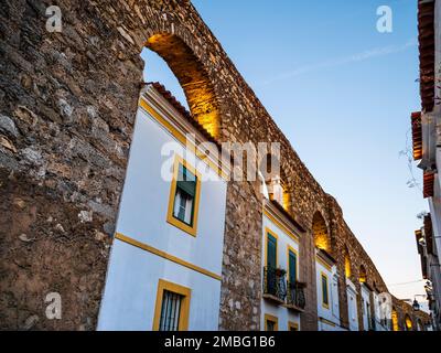 Vista pittoresca di Evora e delle sue tradizionali case bianche incorporate negli archi dell'acquedotto di Prata, nella regione dell'Alentejo, Portogallo Foto Stock