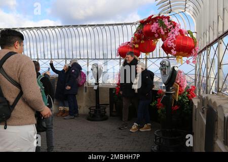 New York, Stati Uniti. 20th Jan, 2023. La gente posa per le foto davanti alle decorazioni per il Capodanno lunare cinese all'osservatorio del ponte dell'Empire state Building a New York, Stati Uniti, il 20 gennaio 2023. L'Empire state Building ha dato il via alle celebrazioni del Capodanno lunare il venerdì mattina con illuminazione cerimoniale e presentazione della Fifth Avenue Window Exhibition. Credit: Liu Yanan/Xinhua/Alamy Live News Foto Stock